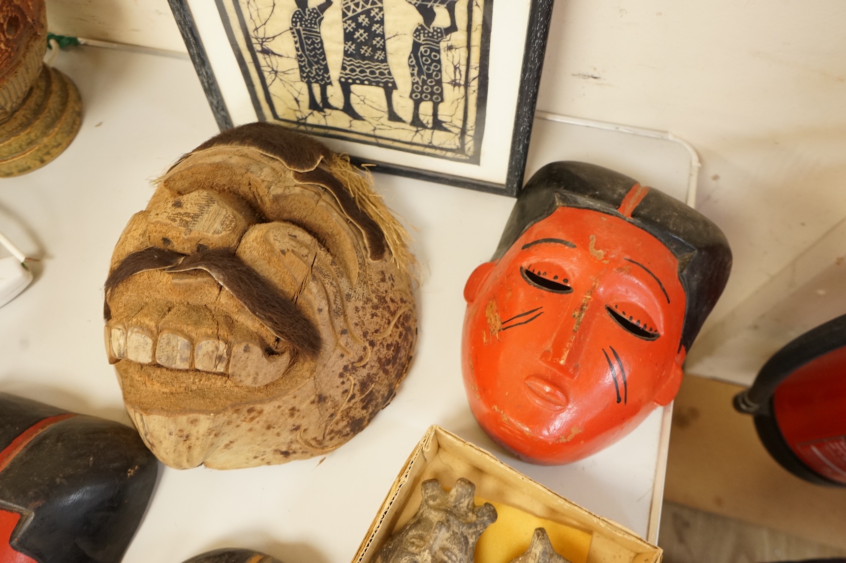 Four Japanese masks, two small oil lamps and a framed batik-16.5high x 19cm wide